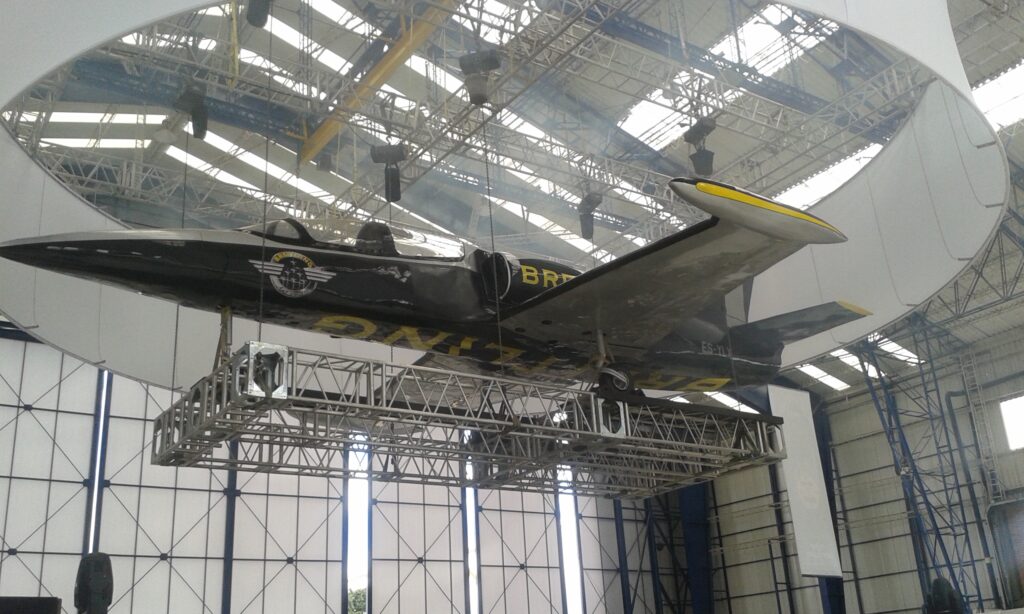 Estructura aérea en truss de aluminio con sistema de izaje para subir, bajar y suspender avión en evento de marca Breitling, por Tempo Ingeniería de Eventos.